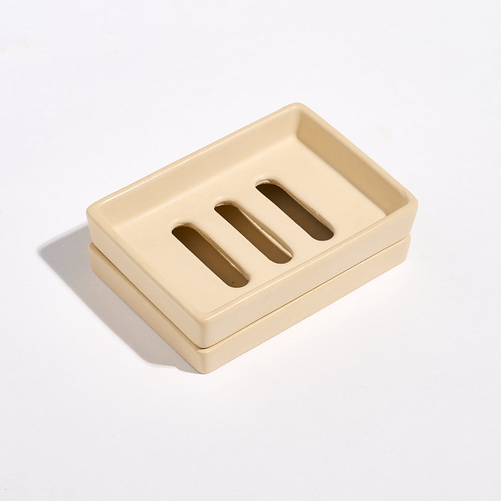 Yellow sandstone Jesmonite soap dish with three drainage holes on a tray on a white background
