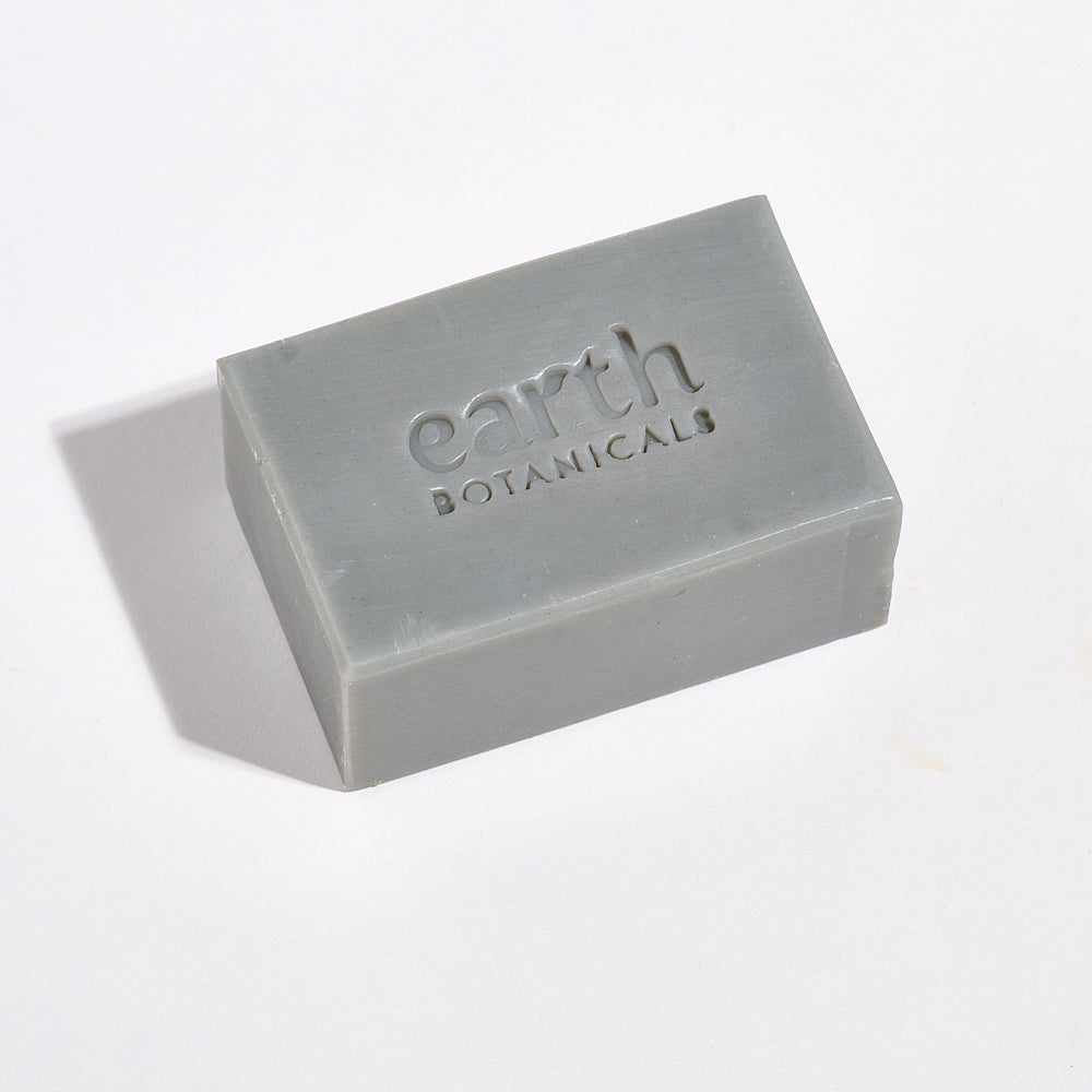 Bar of soap with 'earth botanicals' branding on a light background
