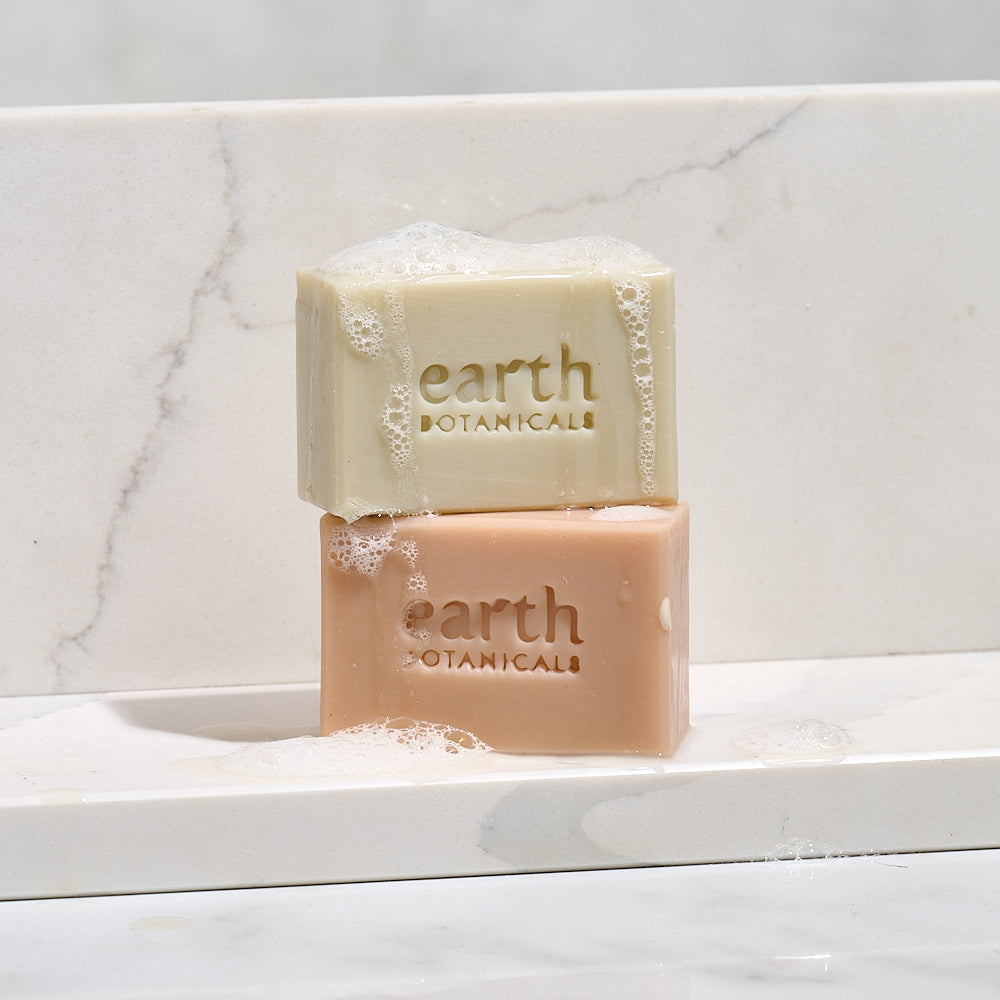 Two bars of Earth Botanicals soap on a marble surface