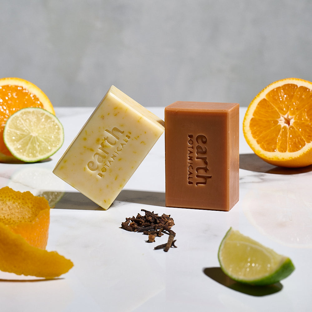 Aurora  sweet orange cypress and clove bud natural soap bar with fresh clove buds lime and orange and shown with Marigold from Earth Botanicals