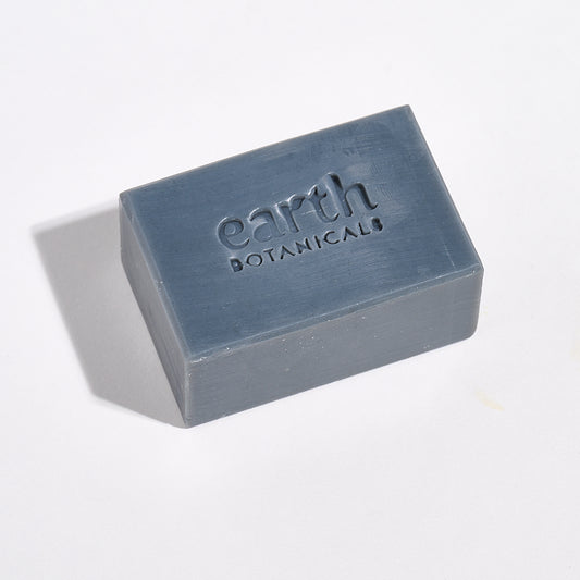 Bar of soap with 'earth botanicals' branding on a light gray background