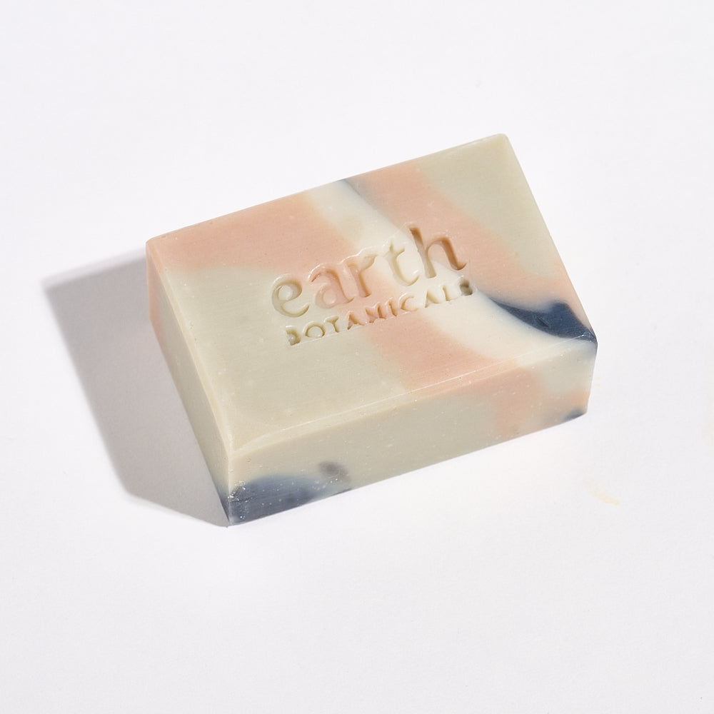 Bar of soap with 'earth botanicals' branding on a light background