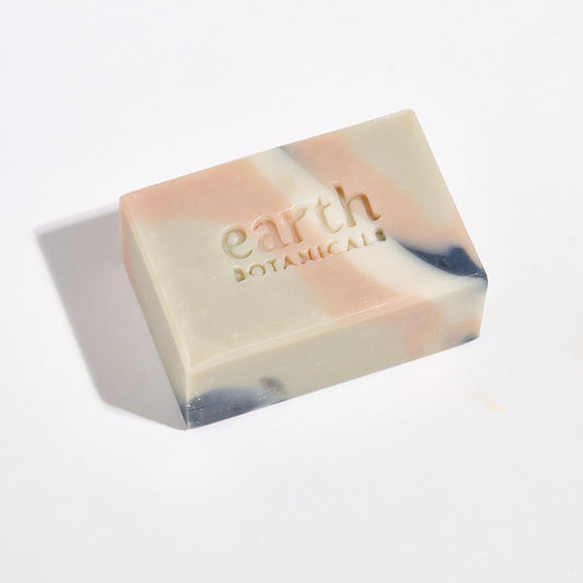 Bar of soap with 'earth botanicals' branding on a light background