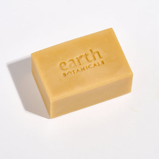Bar of soap with 'earth botanicals' branding on a light background