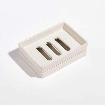 Portland Stone-coloured Jesmonite soap dish with three slots and a tray on a light gray background.